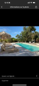 a picture of a pool with benches and a straw umbrella at Residence Paolina in Calvi