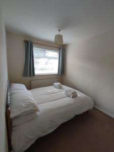 una camera da letto con un grande letto bianco e una finestra di Sheffield meadowhall interchange house with off street parking a Sheffield
