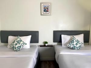 two beds sitting next to each other in a room at Chanmel Riverside in Chanthaburi