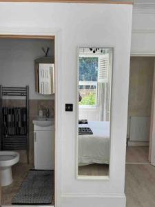 um quarto com uma cama e uma casa de banho com um espelho em Bournemouth. Private Self Contained space. em Bournemouth