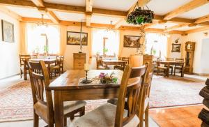 a dining room with a wooden table and chairs at Penzion Flídr in Poděbrady