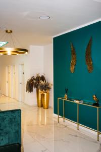 a living room with a green wall and two potted plants at M-Pire Hotel Berlin in Berlin