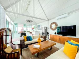 a living room with a couch and a table at One Villa Samaesarn in Ban Samae San