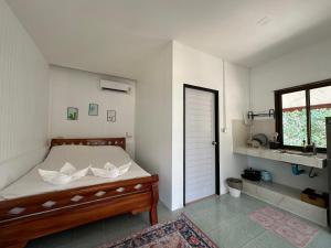 Un dormitorio con una cama con paredes blancas y una ventana en Cozy house in Chaloklum, en Mae Haad