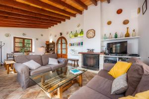 a living room with couches and a tv and a fireplace at Can Bordoy in Fornalutx