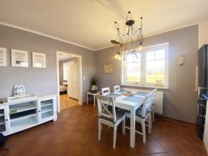 een eetkamer met een witte tafel en stoelen bij Ferien im Wangerland Ferienwohnung MUSCHEL Minsen Schillig Hund Pool Sauna in Wangerland