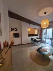 ein großes Wohnzimmer mit einem Tisch und Stühlen in der Unterkunft Appartement intra muros avec cour privée in Avignon