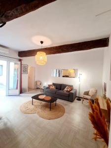 ein Wohnzimmer mit einem Sofa und einem Tisch in der Unterkunft Appartement intra muros avec cour privée in Avignon