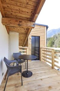 un patio con mesa y sillas en una terraza en Locanda Boton D'Oro en Auronzo di Cadore