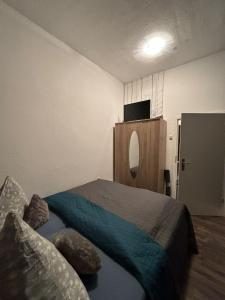 a bedroom with a bed and a tv on the wall at Fewo Nähe Norddeich/ Nessmersiel in Hagermarsch