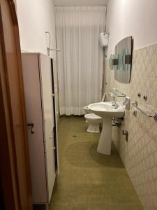 La salle de bains est pourvue d'un lavabo, de toilettes et d'un miroir. dans l'établissement Appartamento Sul Mare, à Porto San Giorgio