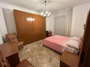 ポルト・サン・ジョルジョにあるAppartamento Sul Mareのピンクベッド1台と大きなキャビネット付きのベッドルーム1室が備わります。