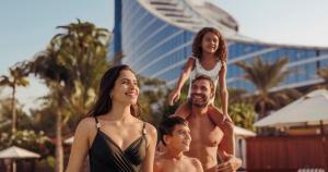 a group of people standing next to a pool at Jumeirah Beach Hotel Dubai in Dubai