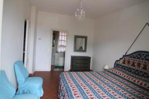 1 dormitorio con 1 cama y 1 silla en Five Lands Pink Cottage, en Levanto