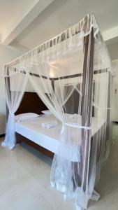 a canopy bed with mosquito netting in a room at Dream Villa with Pool in Habaraduwa