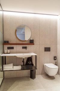 W łazience znajduje się umywalka, toaleta i lustro. w obiekcie HasHotel w mieście Hasselt