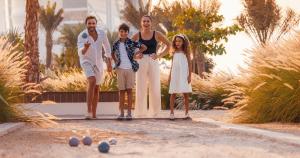 a family posing for a picture in a garden at Jumeirah Beach Hotel Dubai in Dubai
