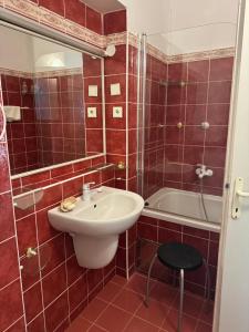 baño de azulejos rojos con lavabo y bañera en Ubytování v Mníšku pod Brdy u lesa, en Mníšek pod Brdy