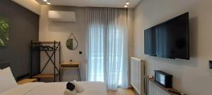 1 dormitorio con 1 cama y TV de pantalla plana en Lago Suite en Kastoria