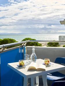 a table with a book and glasses and a book at Hotel Bahia in Lignano Sabbiadoro