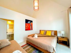 a bedroom with a bed with a cat sitting on it at One Villa Samaesarn in Ban Samae San