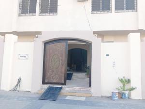 a door of a white building with a stairway leading to it at Soma Apt in Al Madinah