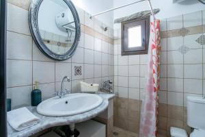 a bathroom with a sink and a mirror and a toilet at Savvas's Traditional House Paros in Episkopianá +22 photos