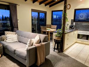 a living room with a couch and a kitchen at TekapoB2 Lakeview Apartment in Lake Tekapo