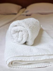 een stapel witte handdoeken op een bed bij Willa Sanssouci in Kudowa-Zdrój
