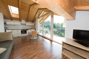 a living room with a couch and a large window at Residence Fiegl in Schenna