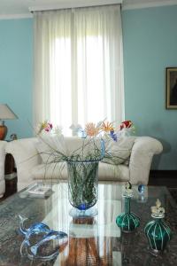 un soggiorno con un vaso con fiori su un tavolo di La Maison Du Charme Modena a Modena