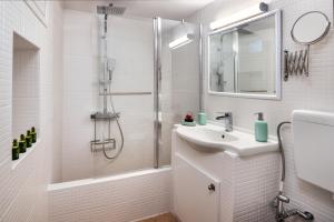 a white bathroom with a sink and a shower at Canaves Karterados - Hermes in Karterados