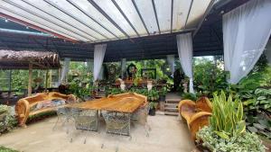 a patio with a wooden table and chairs at Paglinawan Organic Eco Farm in Molave