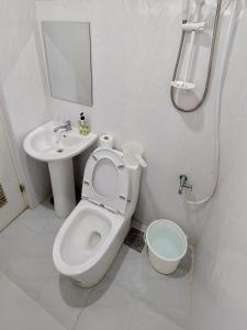 a white bathroom with a toilet and a sink at Paglinawan Organic Eco Farm in Molave
