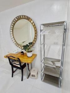 una mesa con espejo, una silla y un estante en Paglinawan Organic Eco Farm, en Molave