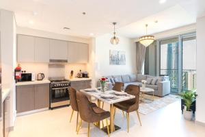 a kitchen and living room with a table and chairs at Fabulous 2BR high floor luxury apartment with Burj Khalifa view in Dubai