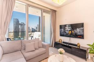 a living room with a couch and a large window at Fabulous 2BR high floor luxury apartment with Burj Khalifa view in Dubai
