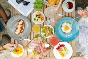 a wooden table with plates of food on it at Hotel Bahia in Lignano Sabbiadoro +11 photos