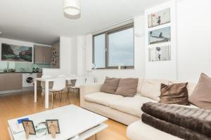 a living room with a couch and a table at 2 Bedroom East London Apartment With Amazing Views in London