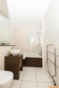 y baño con lavabo, aseo y ducha. en 2 Bedroom East London Apartment With Amazing Views en Londres