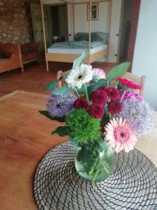 a vase filled with flowers sitting on a table at Erlebnishof Bauernhof Ferienhaus 