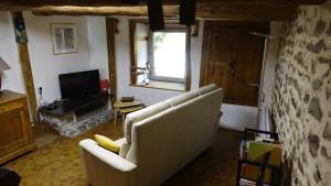 un soggiorno con divano e TV di Un grand gîte *** à Lavoûte-Chilhac a Lavoûte-Chilhac