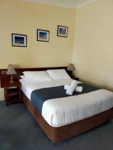 a bedroom with a large bed with white pillows at Bayview Motel in Esperance