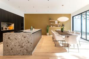 uma cozinha e sala de jantar com mesa e cadeiras em Villa Marie em Dijon