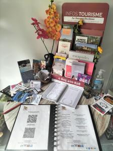 a table with books and magazines on top of it at Ile des Plaisirs - Domaine de Charme et table d'hôtes Caraïbéenne in Graulhet