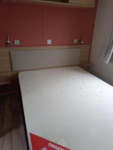 łóżko w pokoju z białym materacem w obiekcie Stéphanie w mieście Biville-sur-Mer