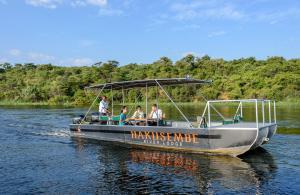 un groupe de personnes sur un bateau sur l'eau dans l'établissement Hakusembe River Camping2Go, 