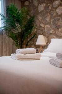 two towels sitting on top of a bed at Num Suites & Lofts Athens in Athens