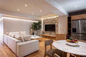 a living room with a white couch and a table at Num Suites & Lofts Athens in Athens