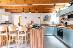 a kitchen with blue cabinets and a table with chairs at Maison familiale sud Nantes in Bouguenais +13 photos